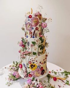 a three tiered cake decorated with flowers on a table