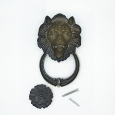 an iron lion head door knocket and screws