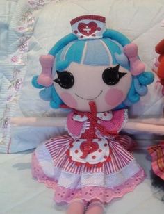 two stuffed animals sitting on top of a bed next to each other and one is wearing a dress