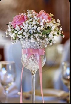 a vase filled with pink roses and baby's breath sitting on top of a table