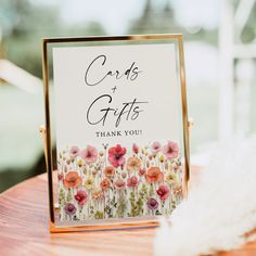 a card that says cards and gifts is on top of a table next to feathers