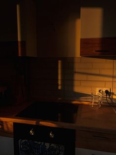 a kitchen with a sink, stove and counter top in the sun shining on the wall