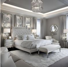 a white bed sitting in a bedroom on top of a fluffy rug next to a window