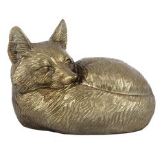 a gold colored statue of a sleeping cat