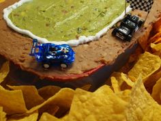 a toy truck is parked on top of a tortilla with guacamole