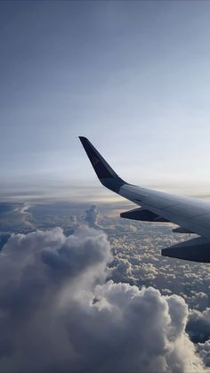 an airplane is flying high above the clouds