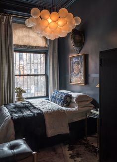 a bedroom with a bed, chair and large window in it's dark room