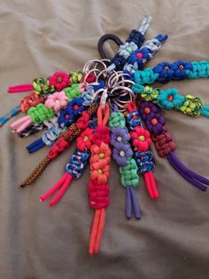 a bunch of different colored bracelets on a bed