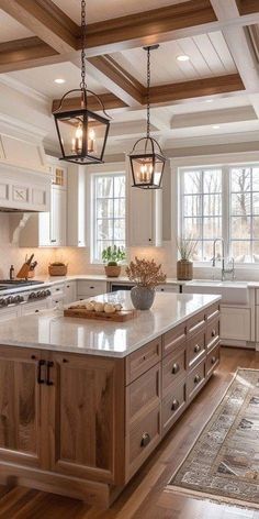 a large kitchen with an island in the center and two hanging lights above it's counter tops