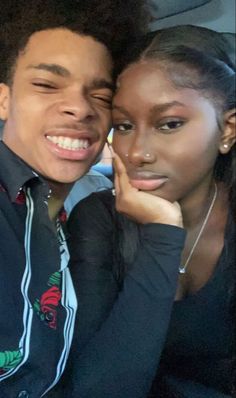 a young man and woman are sitting in the back seat of a car smiling at the camera