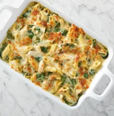 a casserole dish filled with pasta and spinach