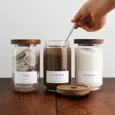 a person is spooning sugar into two jars