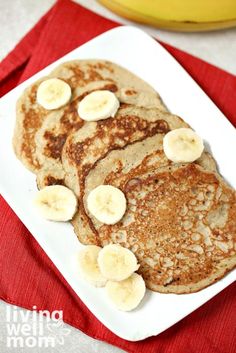 pancakes with banana slices and syrup on a white plate