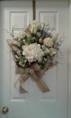 a bouquet of flowers is hanging on the front door to decorate it's entrance