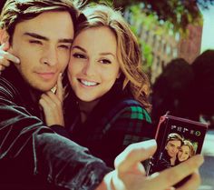 a young man and woman taking a selfie with their cell phone in front of them