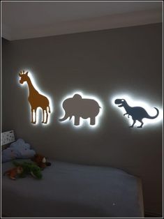 three different types of animals are on the wall above a bed with stuffed animals in it