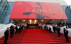 men in uniform stand on the red carpeted steps leading up to a large sign