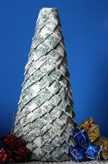 a small white christmas tree sitting on top of a table next to some wrapped presents