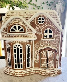 a brown and white doll house sitting on top of a counter