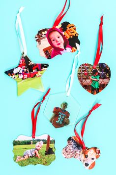 four christmas ornaments are hanging on a blue background with red and white ribbon around them