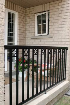 a balcony with black iron railing and flowers