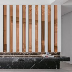 a marble bench with wooden slats on the wall