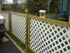 a white truck parked next to a wooden fence with lattice design on it's sides