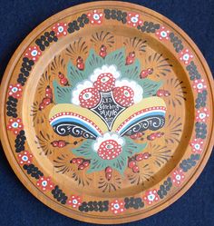 a decorative wooden plate with designs on it