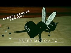 a paper mosquito on top of a wooden table