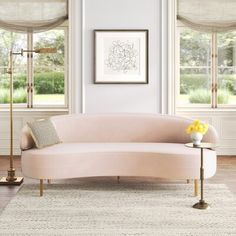 a living room filled with furniture and windows covered in shades of light colored fabric coverings