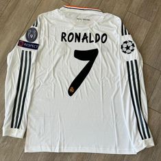 a white shirt with black stripes on the sleeves and number seven printed on the chest