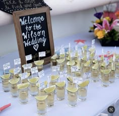 small shot glasses with lemon wedges are on the table for guests to drink from