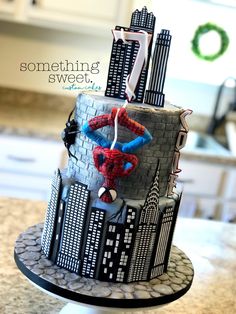 a spiderman themed birthday cake on top of a kitchen counter with the words something sweet above it