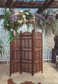 a room divider decorated with flowers and greenery