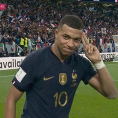 a soccer player holding his hand up in the air