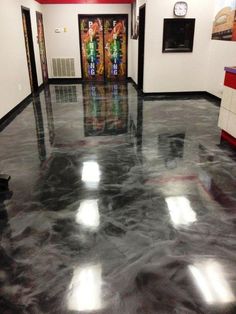 an empty room with black and white marble flooring, red walls and clock on the wall