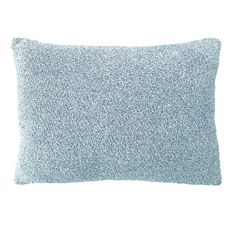 a blue pillow on a white background with small speckles in the middle and bottom