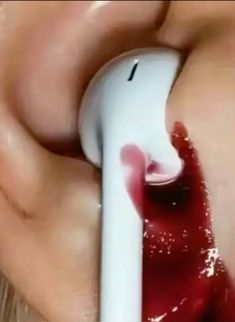 a close up of a person using an electronic device to examine blood on their lips