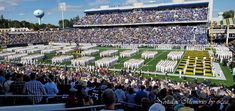 a football stadium filled with lots of people and marching bandleaders on the field