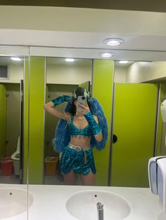 a woman taking a selfie in front of a mirror wearing a blue outfit and holding a cell phone