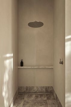 an empty bathroom with white walls and tile flooring