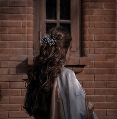 the back of a woman's head wearing a silver dress and a tiara