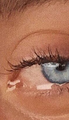 an eye with long lashes and blue eyes