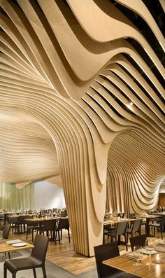 the interior of a restaurant with wood slats on the ceiling and tables in chairs