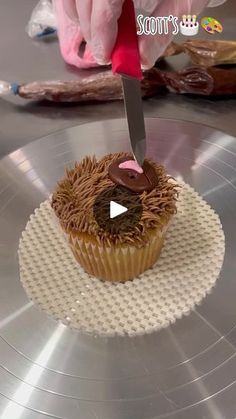 someone cutting into a cupcake with a knife