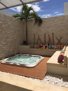 an outdoor jacuzzi is shown in the middle of a patio with seating and pillows