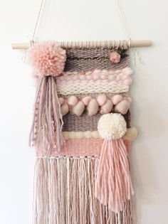 a wall hanging made with yarn and pom poms