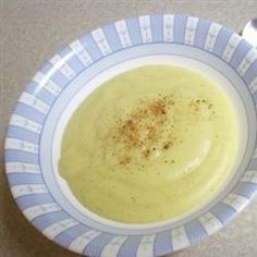 a bowl filled with soup on top of a counter next to a fork and spoon