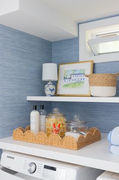 a white washer sitting next to a dryer in a room with blue walls