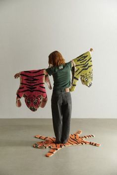 a woman holding two stuffed animals in front of her face and standing on the floor